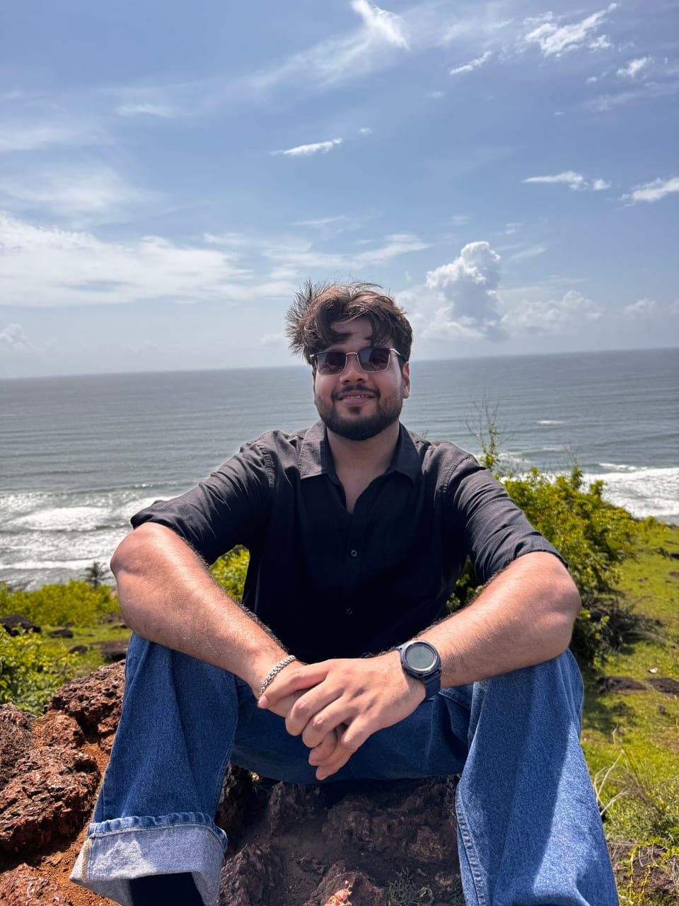 Gaurav sitting on a clifftop above the sea
