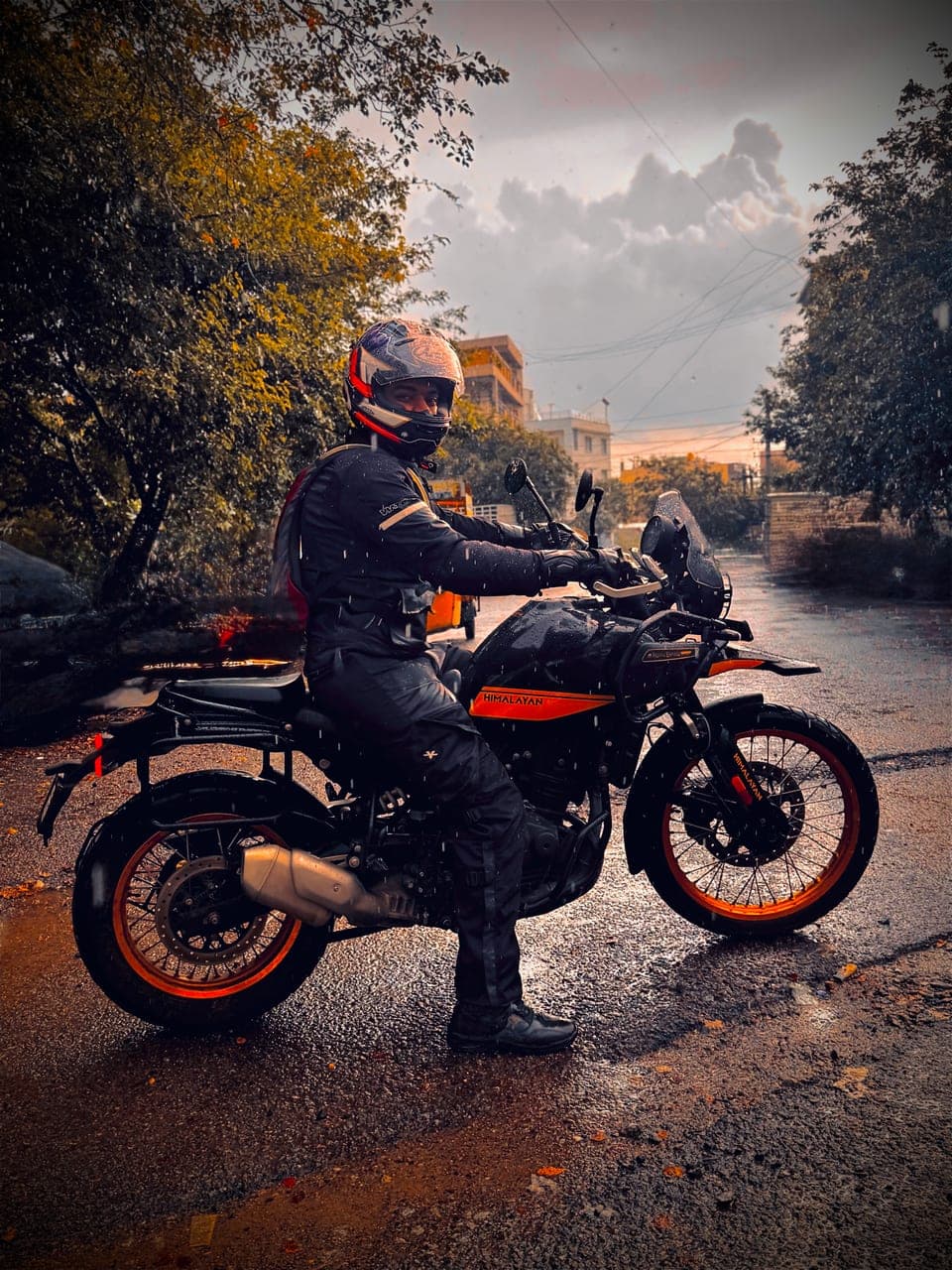 Gaurav in riding gear on his Royal Enfield Himalayan, on a wet road